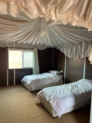 two beds in a room with a ceiling at My X wadirum in Wadi Rum