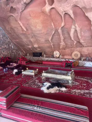 a room with a red carpet and a rock wall at My X wadirum in Wadi Rum