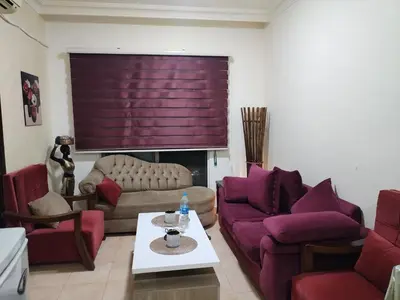 a living room with purple chairs and a couch at عمان in Jurf ad Darāwīsh