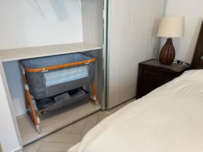 a room with a bed and a suitcase in a bedroom at Ayla Beach Apartment in Aqaba