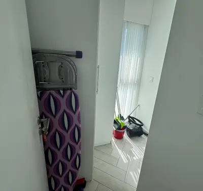 a purple refrigerator in a room with a hallway at Ayla Beach Apartment in Aqaba