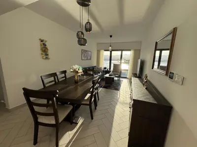 a dining room with a wooden table and chairs at Ayla Beach Apartment in Aqaba