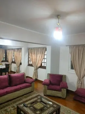 a living room with purple couches and a table at جرف العز هاوس in Jurf ad Darāwīsh
