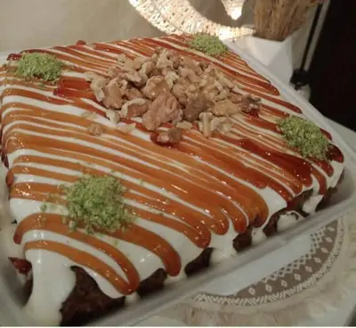 a cake with white frosting and nuts on it at جرف العز هاوس in Jurf ad Darāwīsh