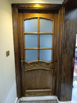 a wooden door with a window in a room at جرف العز هاوس in Jurf ad Darāwīsh