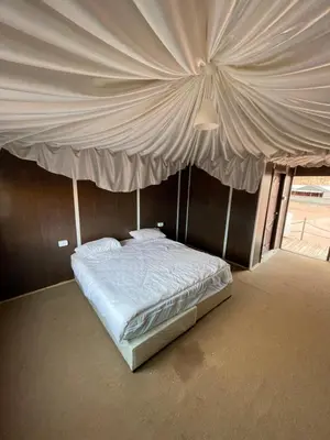 a bed with a canopy in a room at Bedouin Luxury Camp in Wadi Rum