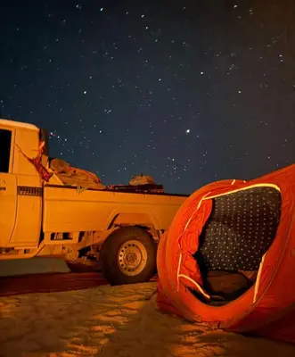 a white truck parked in the snow with a tent at Bedouin Luxury Camp in Wadi Rum