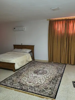 a bedroom with a bed and a rug on the floor at Shafa Badran Studio in Jurf ad Darāwīsh