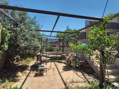 a patio with a table and a bench in a yard at Shafa Badran Studio in Jurf ad Darāwīsh