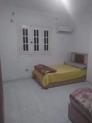 a bedroom with two beds in a white room at ابيت السعاده in Ar Ramthā
