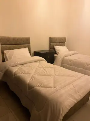 two beds sitting next to each other in a room at Family-Friendly Garden Stay in Jurf ad Darāwīsh