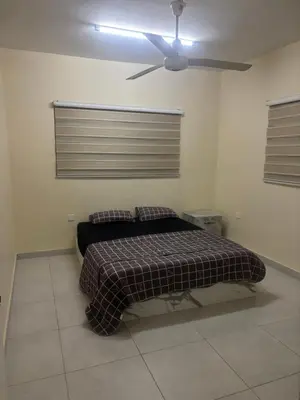 a bedroom with a bed with a ceiling fan at Bubbles in Jurf ad Darāwīsh