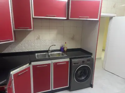 a kitchen with a sink and a washing machine at Bubbles in Jurf ad Darāwīsh