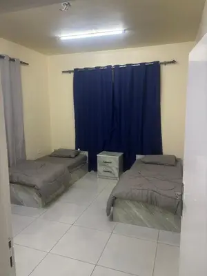 two beds in a room with blue curtains at Bubbles in Jurf ad Darāwīsh