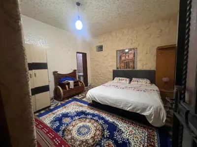 a bedroom with a bed and a rug on the floor at Mohmad House in Jurf ad Darāwīsh