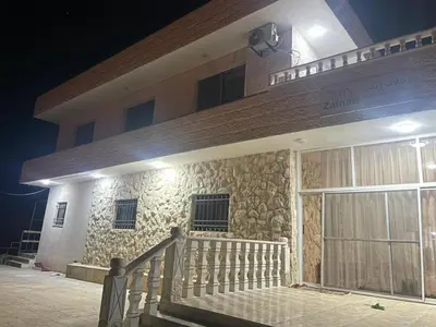 a building with a staircase in front of it at night at Mohmad House in Jurf ad Darāwīsh