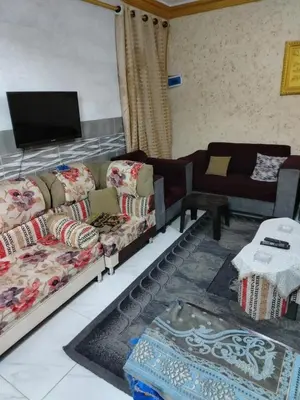 a living room with two couches and a tv at شقة الياسمين عمّان الأرضيّة للعائلات in Amman