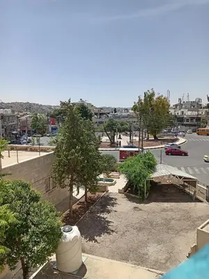 a view of a parking lot with trees and a street at Stay with Saja Homey Room Heart of Weibdeh in Jurf ad Darāwīsh