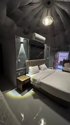 a bedroom with two beds in a room with a ceiling at RUM FLORAA LUXURY CAMp in Wadi Rum