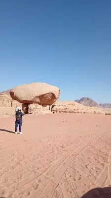 a person standing in the sand in the desert at Wasan Camp Wadi Rum in Wadi Rum
