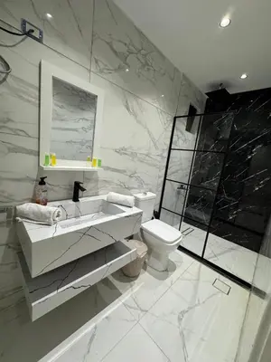 a white bathroom with a sink and a toilet at Oia chalet in Ash Shāghūr