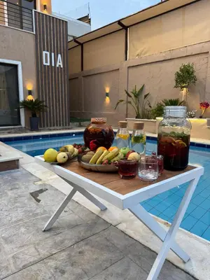 a tray of fruit on a table next to a pool at Oia chalet in Ash Shāghūr