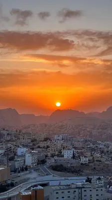 a city with the sun setting in the background at Tetra Tree Hotel 1 in Wadi Musa