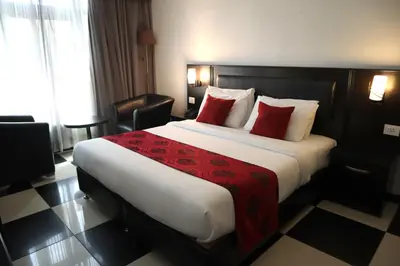 a hotel room with a large bed with red pillows at Easy Inn Hotel Suites in Amman