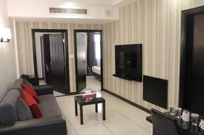 a living room with a couch and a flat screen tv at Easy Inn Hotel Suites in Amman