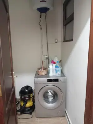 a laundry room with a washing machine in a corner at Stay with Saja Room in Weibdeh in Jurf ad Darāwīsh