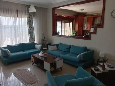 a living room with blue couches and a table at Stay with Saja Room in Weibdeh in Jurf ad Darāwīsh