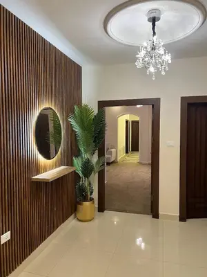 a hallway with a chandelier and a plant in a room at Modern Luxe Getaway in Amman