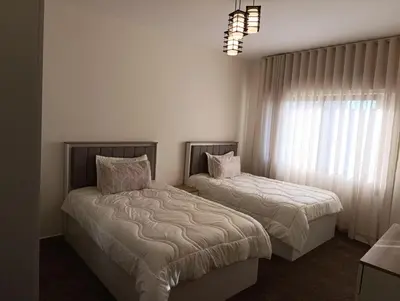 a bedroom with two beds and a window at Modern Luxe Getaway in Amman