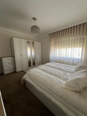 a bedroom with a large white bed and a chandelier at Modern Luxe Getaway in Amman