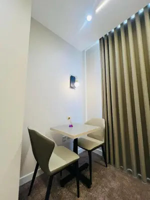 a table and chairs in a room with a curtain at فندق الأمراء بلازا in Ma‘ān