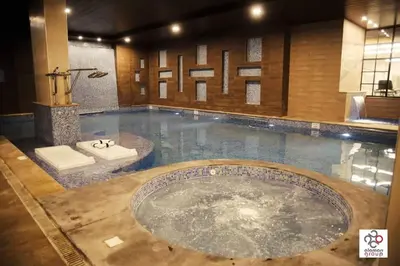 a large swimming pool with a tub in the middle at Der Ghbar Luxe in Amman
