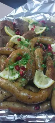 a tray of food with meat and vegetables on foil at الازرق فارم in Al Azraq ash Shamālī