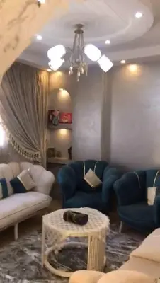 a living room with blue couches and a table at الازرق فارم in Al Azraq ash Shamālī