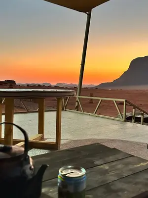 a table with a view of the desert at sunset at Wadi Rum Sha ar Nights in Wadi Rum