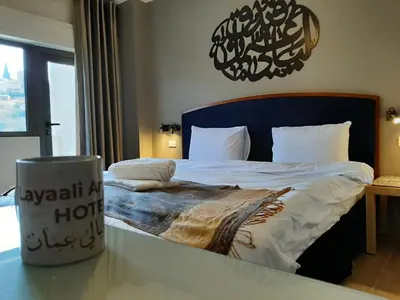 a bedroom with a large bed with a table at Layaali Amman Hotel Airport Pickup in Amman