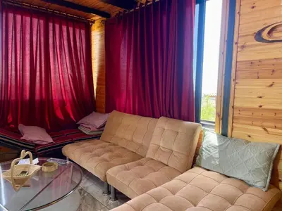a living room with a couch and red curtains at كوخ واستراحة شيخ الجبل in Ajloun