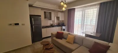 a living room with a couch and a kitchen at فورتاليزا للإسكان in Jurf ad Darāwīsh
