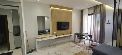 a living room with a table and a television at فورتاليزا للإسكان in Jurf ad Darāwīsh