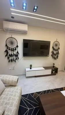 a living room with a flat screen tv on the wall at صبحه هاوس in Şabḩā