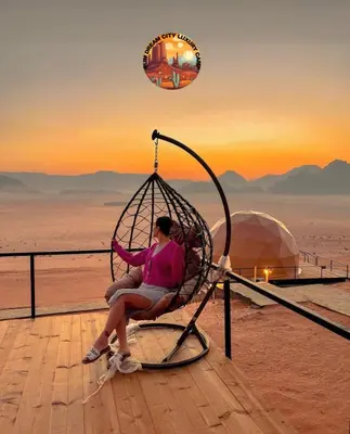 a woman sitting in a swing in the desert at RUM DREAM CITY lUXURY CAMP in Wadi Rum