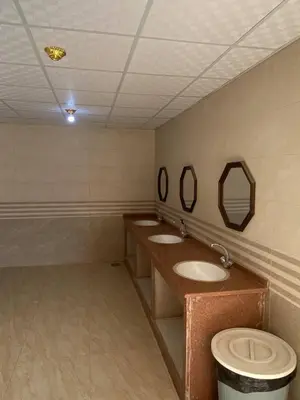 a bathroom with three sinks and a toilet in it at Wadi Rum Desert Experience in Wadi Rum