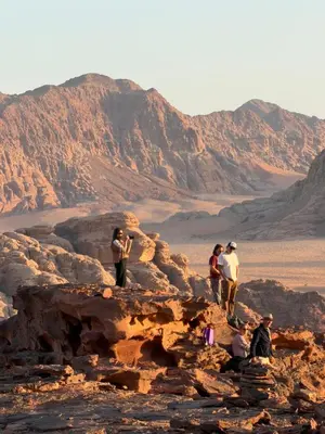a group of people standing on rocks in the desert at Wadi Rum Desert Experience in Wadi Rum