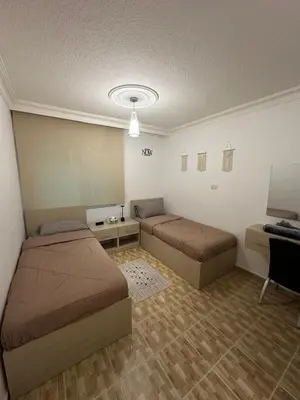 a room with two beds and a desk in it at MK4 - One Bedroom Apartment in Amman