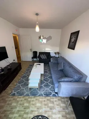 a living room with a couch and a table at MK4 - One Bedroom Apartment in Amman