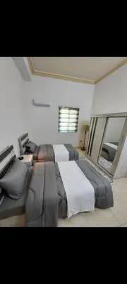 a large bedroom with two beds and a window at Central Jabal Alweibdeh in Amman
